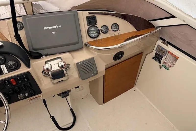 Slide: The Image of 2006 Carver 41 Cockpit Motor Yacht helm with Raymarine navigation systems and steering wheel. - 19
