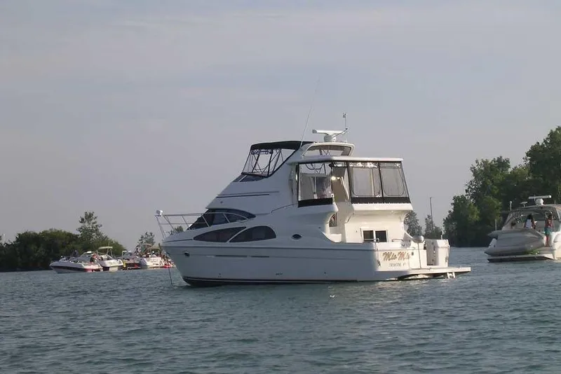 Slide: The Image of 2006 Carver 41 Cockpit Motor Yacht on calm water, surrounded by other boats. - 2