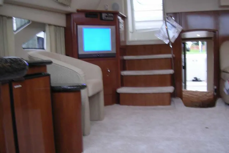 Slide: The Image of Interior of 2006 Carver 41 Cockpit Motor Yacht with TV, stairs, and seating area. - 24