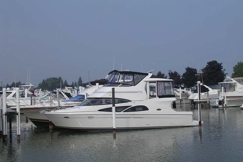 Slide: The Image of 2006 Carver 41 Cockpit Motor Yacht docked in a marina, surrounded by other boats. - 3