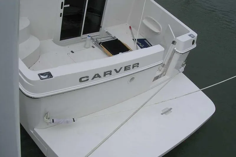 Slide: The Image of 2006 Carver 41 Cockpit Motor Yacht stern view, docked on calm water. - 4