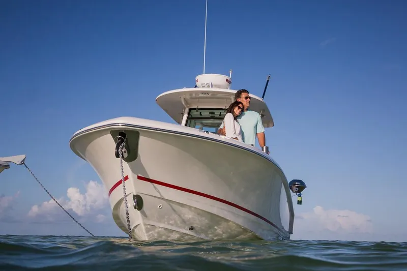 Slide: The Image of Manufacturer Provided Image: 2025 Boston Whaler 250 Outrage boat on water, couple enjoying sunny day. - 11