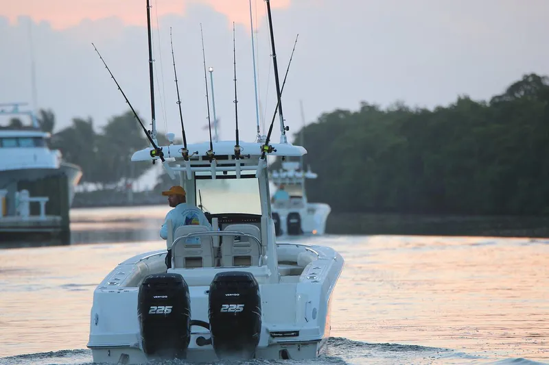 Slide: The Image of Manufacturer Provided Image: 2025 Boston Whaler 250 Outrage boat with fishing rods on a calm waterway at sunset. - 12