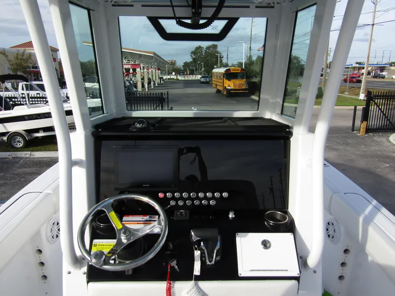 Slide: The Image of 2025 Wellcraft 243 Fisherman boat dashboard with steering wheel and controls. - 17
