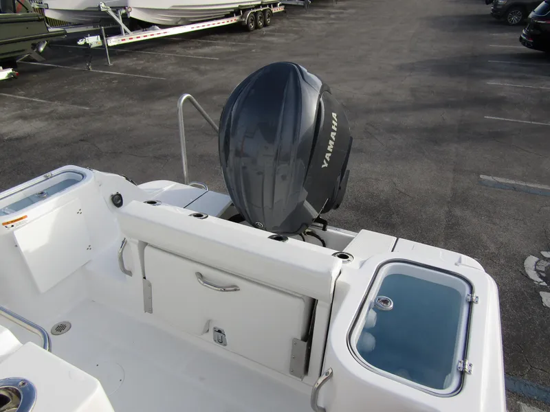 Slide: The Image of 2025 Wellcraft 243 Fisherman boat with Yamaha outboard motor, docked in a parking area. - 27
