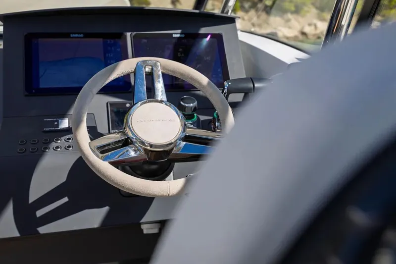 Slide: The Image of Steering wheel and dashboard of 2025 Nimbus W11 boat, featuring modern controls and displays. - 22