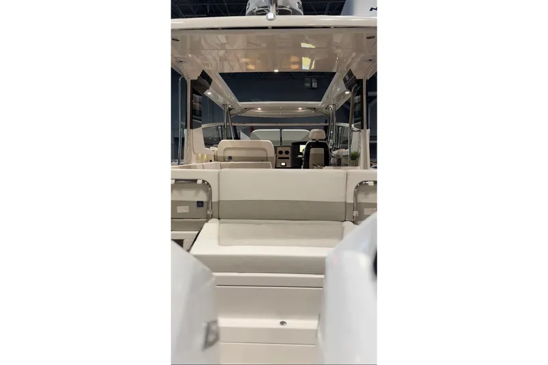 Slide: The Image of Luxurious 2025 Nimbus W11 yacht interior with elegant seating and wooden table, docked by rocky shoreline. - 13