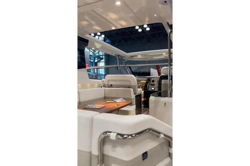 Slide: The Image of 2025 Nimbus W11 yacht interior with sleek design, surrounded by lush greenery and rocky cliffs. - 15