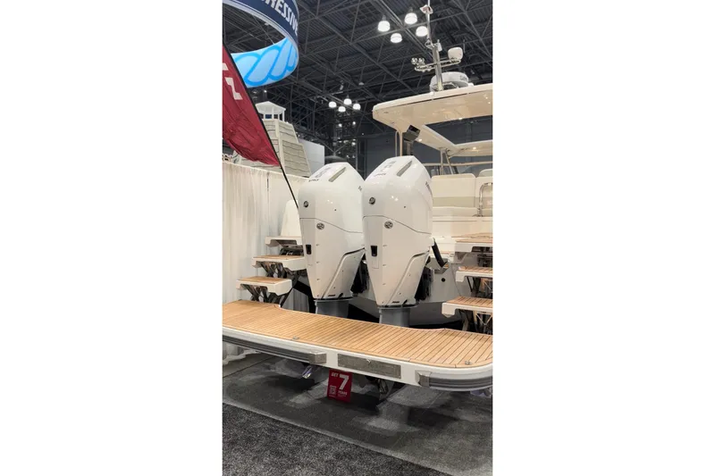 Slide: The Image of 2025 Nimbus W11 boat cruising near rocky shoreline with lush greenery. - 9