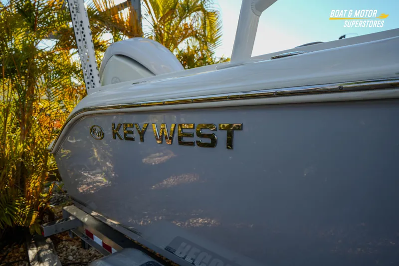 Slide: The Image of 2022 Key West 239 DFS boat side view with logo, surrounded by foliage. - 11