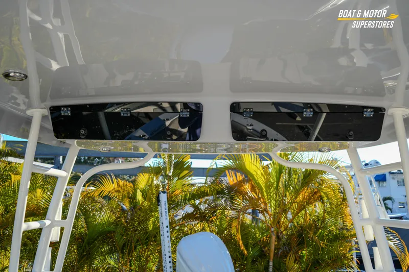 Slide: The Image of 2022 Key West 239 DFS boat interior with overhead storage and tropical background. - 38