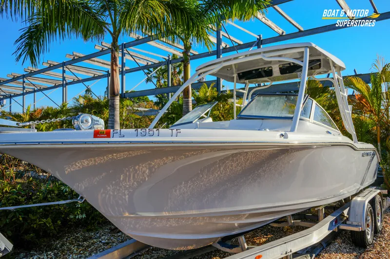 Slide: The Image of 2022 Key West 239 DFS boat on trailer, surrounded by palm trees. - 5