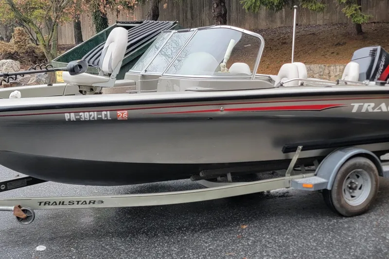 Slide: The Image of 2002 Tracker Tundra 18 WT boat on a trailer, parked outdoors. - 11