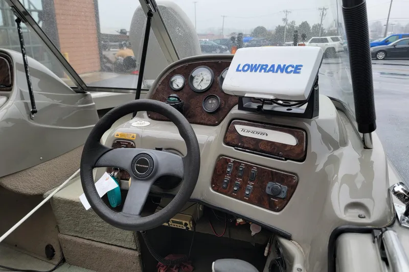 Slide: The Image of 2002 Tracker Tundra 18 WT boat dashboard with steering wheel and Lowrance navigation system. - 6