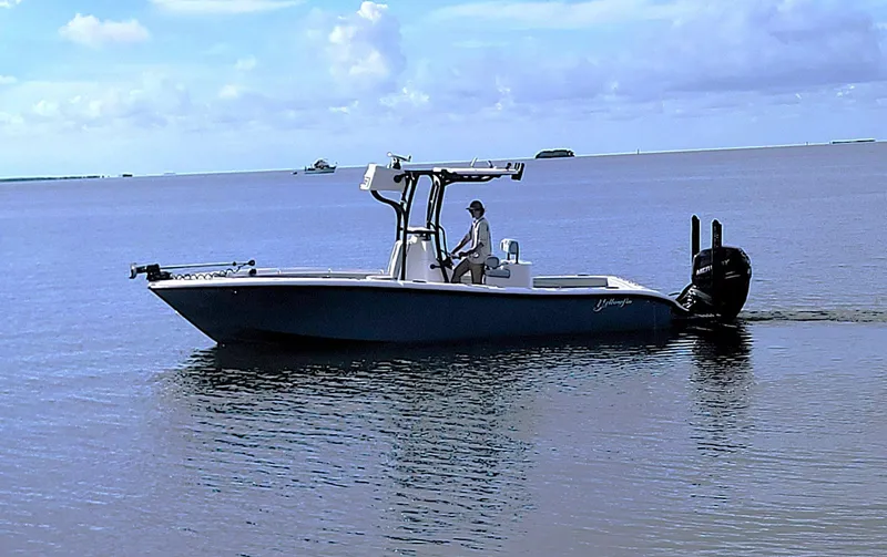 Slide: The Image of 2021 Yellowfin 26 Hybrid boat cruising on calm waters under a clear sky. - 5