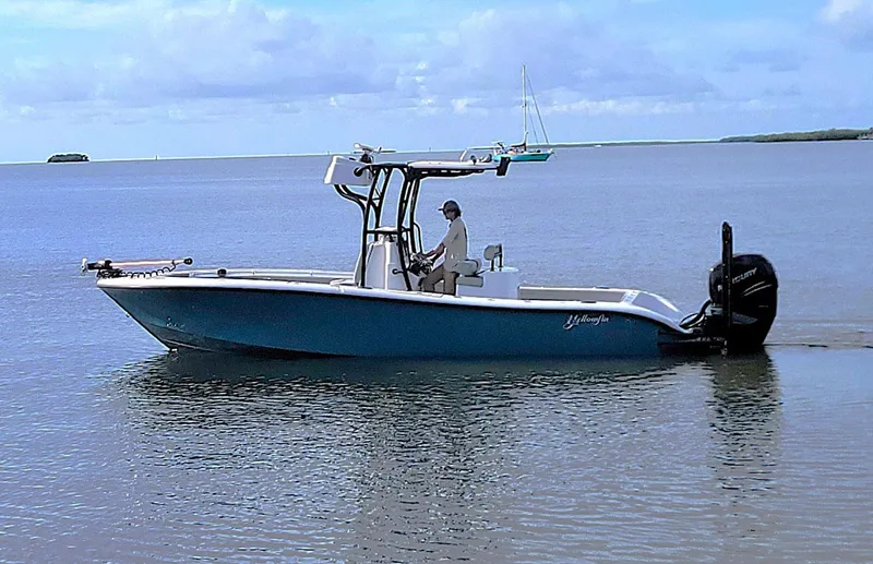 Slide: The Image of 2021 Yellowfin 26 Hybrid boat cruising on calm waters under a clear sky. - 12