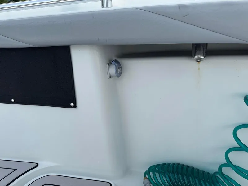 Slide: The Image of 2021 Yellowfin 26 Hybrid boat interior with coiled green hose and black panel. - 21