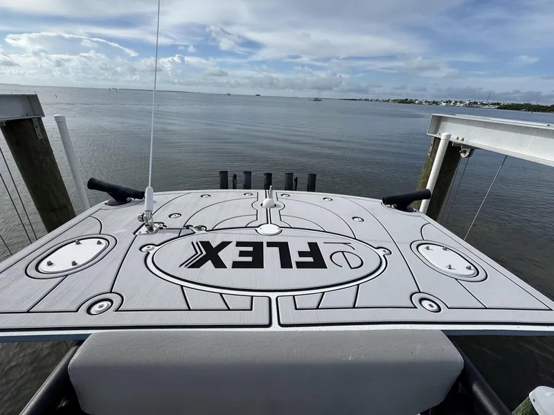 Slide: The Image of 2021 Yellowfin 26 Hybrid boat deck with "FLEX" logo, overlooking calm waters. - 29