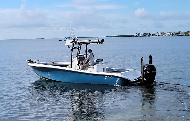 Slide: The Image of 2021 Yellowfin 26 Hybrid boat cruising on calm waters under a clear sky. - 4