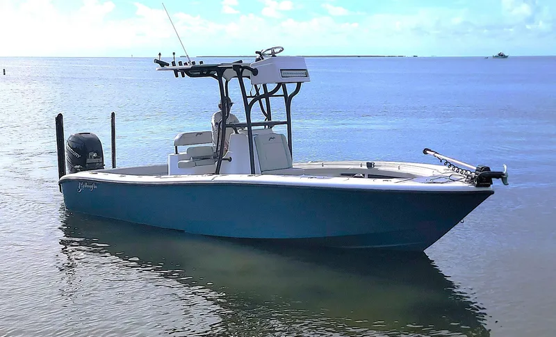 Slide: The Image of 2021 Yellowfin 26 Hybrid boat on calm water under a clear sky. - 9