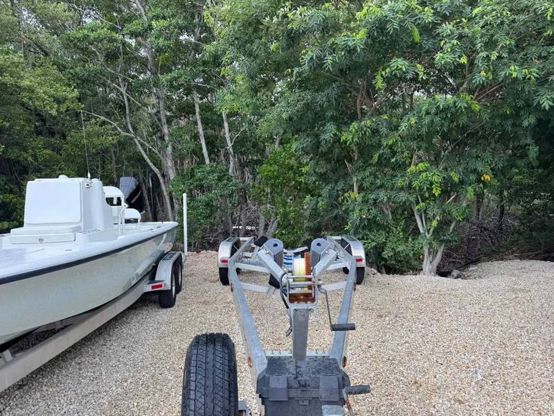 Slide: The Image of 2021 Yellowfin 26 Hybrid boat on trailer, surrounded by lush green trees. - 37