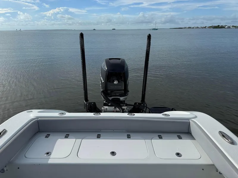 Slide: The Image of 2021 Yellowfin 26 Hybrid boat on calm water, featuring a powerful outboard motor. - 34