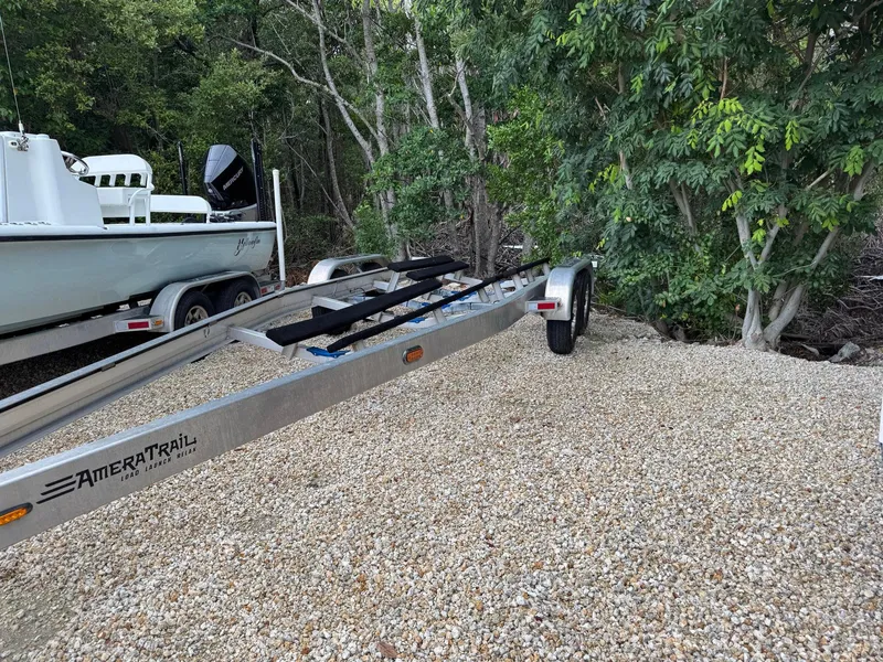 Slide: The Image of 2021 Yellowfin 26 Hybrid boat on AmeraTrail trailer, parked on gravel near trees. - 39
