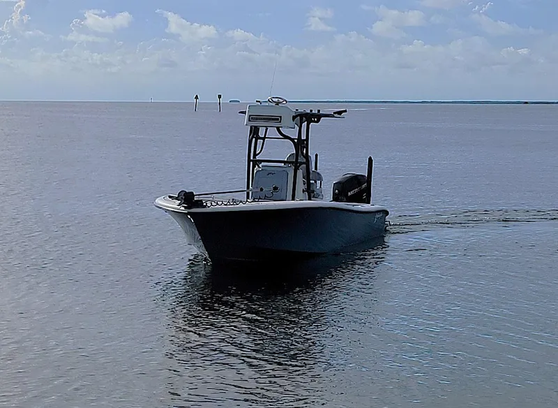 Slide: The Image of 2021 Yellowfin 26 Hybrid boat cruising on calm waters under a clear sky. - 7