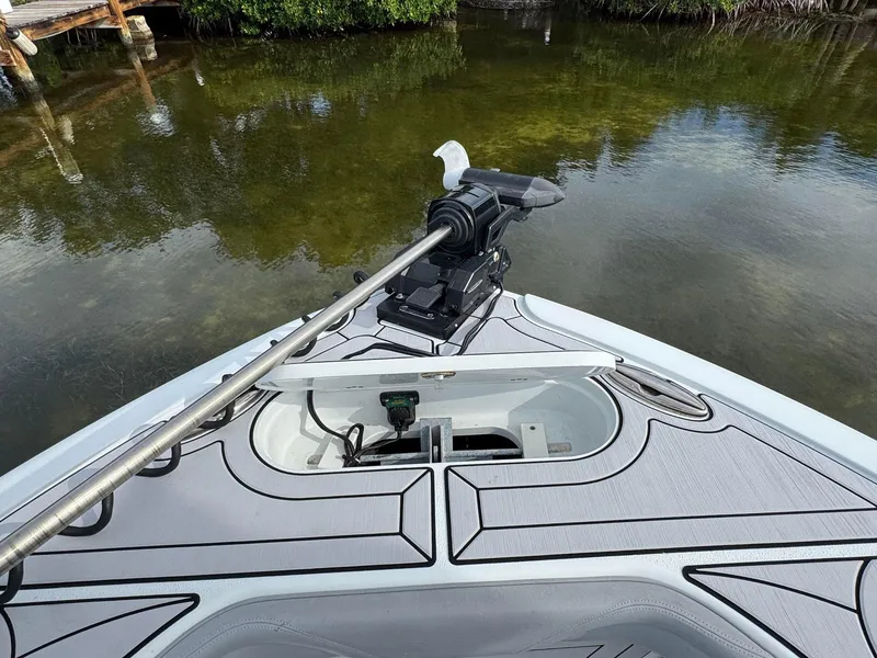 Slide: The Image of 2021 Yellowfin 26 Hybrid boat bow with trolling motor on calm water. - 17