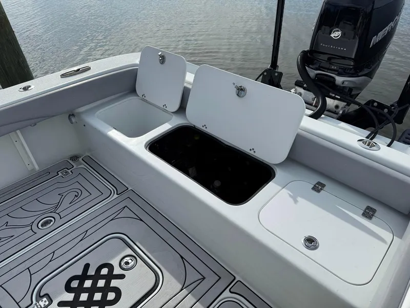 Slide: The Image of 2021 Yellowfin 26 Hybrid boat deck with storage compartments and Mercury engine. - 32