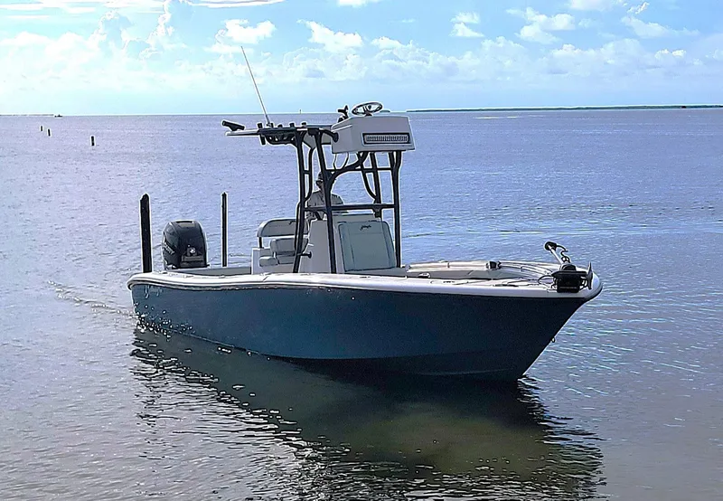 Slide: The Image of 2021 Yellowfin 26 Hybrid boat on calm water under a clear sky. - 8