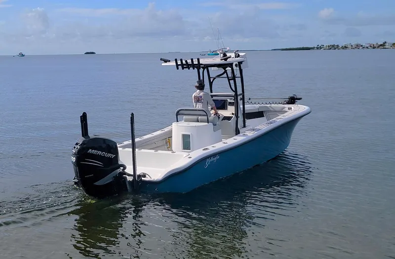 Slide: The Image of 2021 Yellowfin 26 Hybrid boat on calm water with Mercury engine. - 2