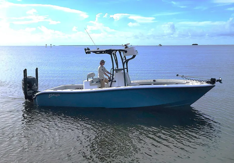 The Image of 2021 Yellowfin 26 Hybrid boat on calm water under a clear blue sky. - 0