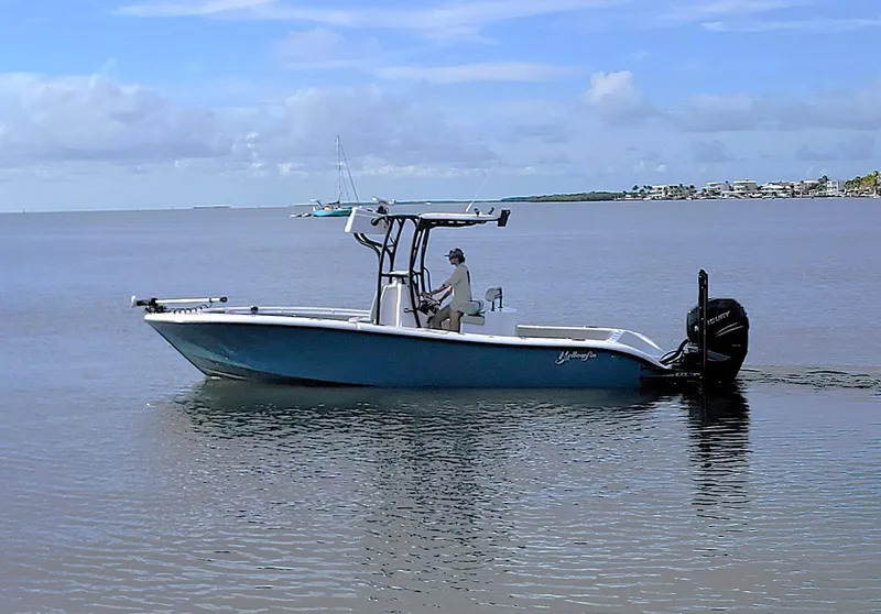 Slide: The Image of 2021 Yellowfin 26 Hybrid boat cruising on calm waters under a clear sky. - 11