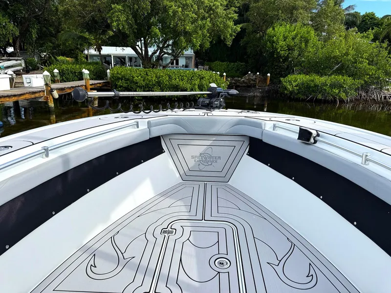 Slide: The Image of 2021 Yellowfin 26 Hybrid boat interior with custom flooring, docked near lush greenery. - 14