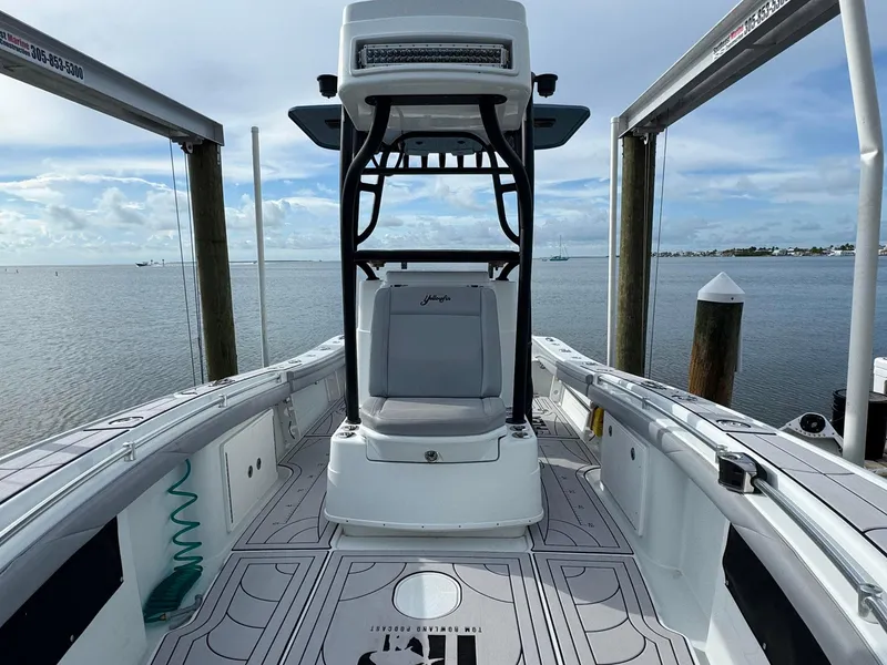 Slide: The Image of 2021 Yellowfin 26 Hybrid boat docked, showcasing spacious deck and seating. - 22