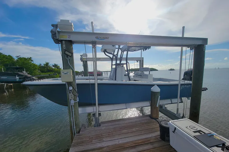 Slide: The Image of 2021 Yellowfin 26 Hybrid boat on lift at sunny waterfront dock. - 13