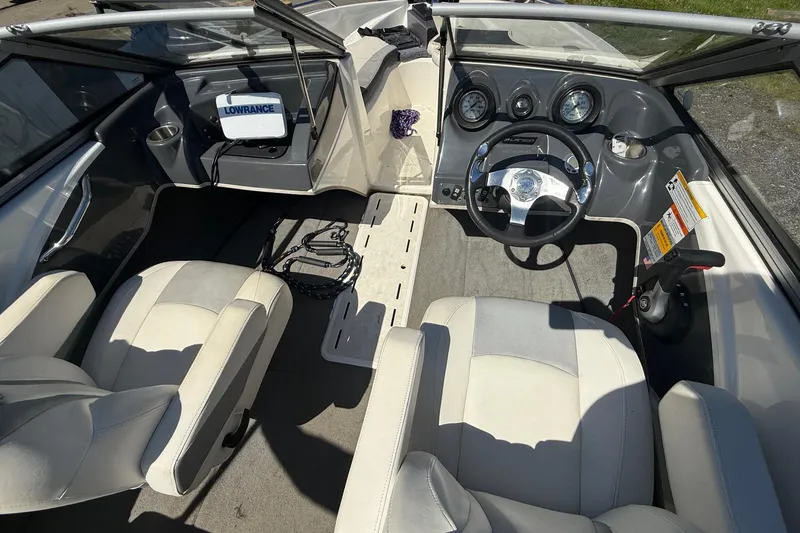 Slide: The Image of 2014 Larson LX 160S OB boat interior with steering wheel and seating. - 11