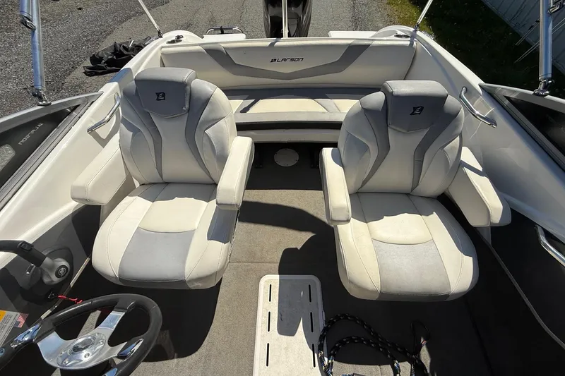 Slide: The Image of 2014 Larson LX 160S OB boat interior with two cushioned seats and steering wheel. - 14