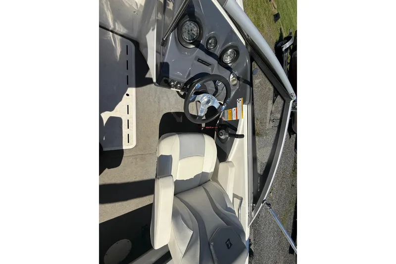 Slide: The Image of 2014 Larson LX 160S OB boat interior with steering wheel and dashboard controls. - 18