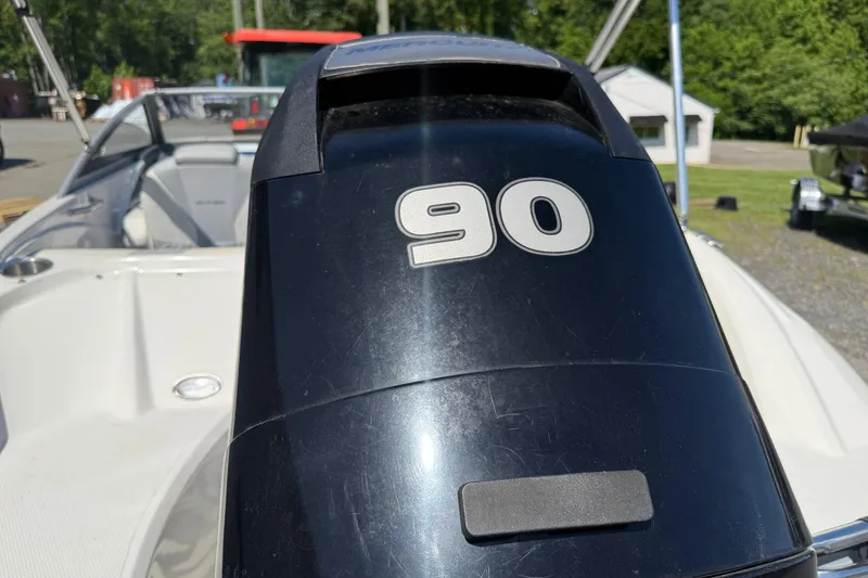 Slide: The Image of 2014 Larson LX 160S OB boat with 90 HP outboard motor, parked outdoors. - 24