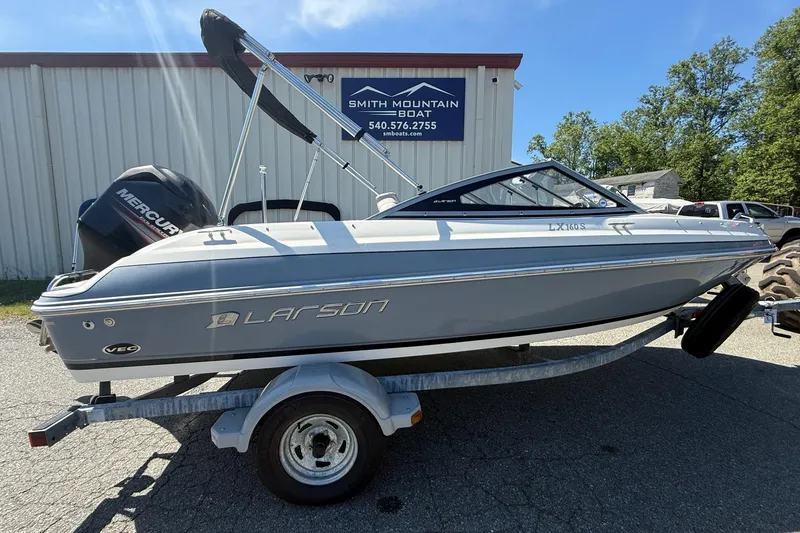 Slide: The Image of 2014 Larson LX 160S OB boat on trailer, parked outside Smith Mountain Boat shop. - 29
