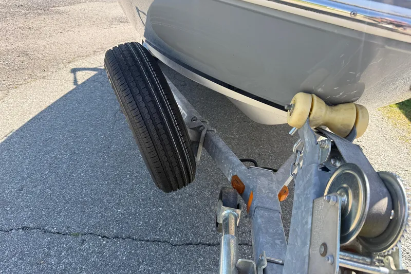 Slide: The Image of Trailer hitch and wheel of 2014 Larson LX 160S OB boat on pavement. - 35