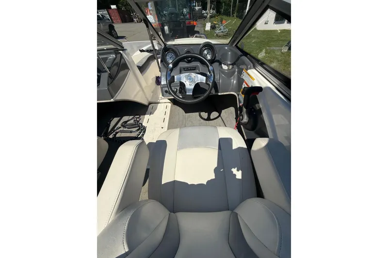 Slide: The Image of 2014 Larson LX 160S OB boat interior with steering wheel and seating. - 7