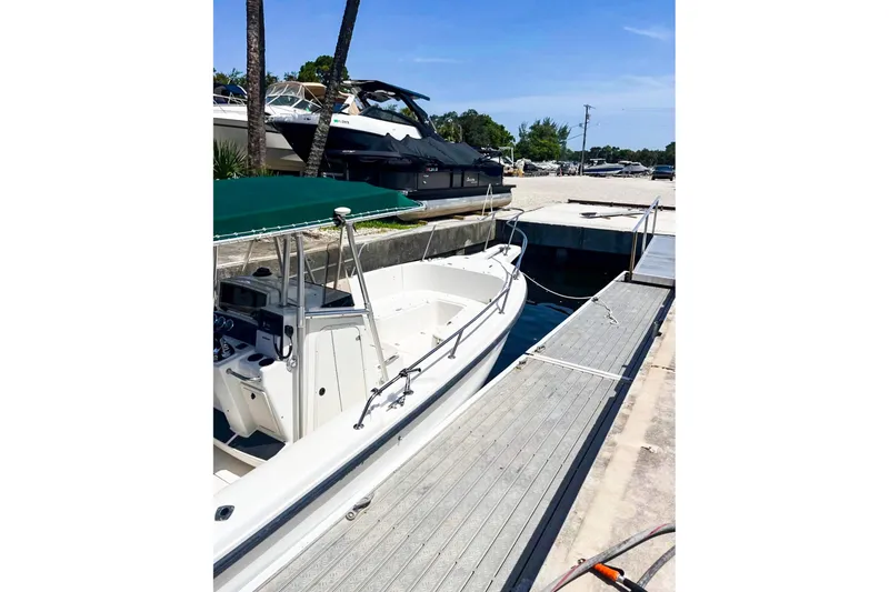 Slide: The Image of Boston Whaler 26 Outrage 2000 docked at marina with green canopy. - 5