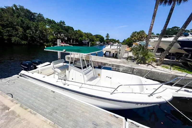 Slide: The Image of Boston Whaler 26 Outrage 2000 model docked by a scenic waterfront. - 6