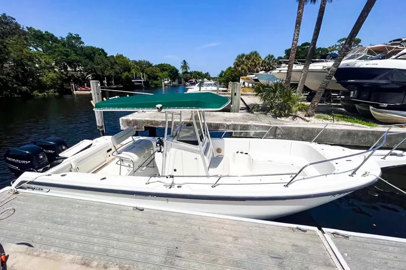 Slide: The Image of 2000 Boston Whaler 26 Outrage boat docked by a scenic waterfront. - 7