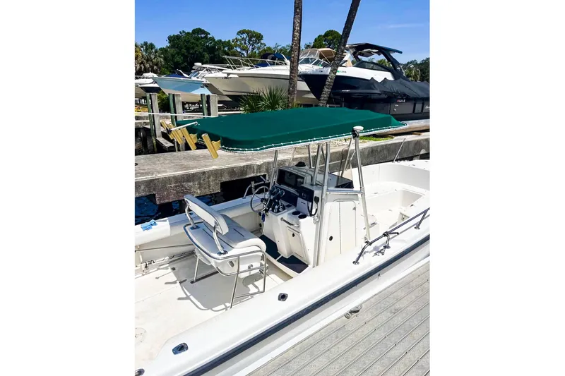 Slide: The Image of 2000 Boston Whaler 26 Outrage boat with green canopy docked at marina. - 8