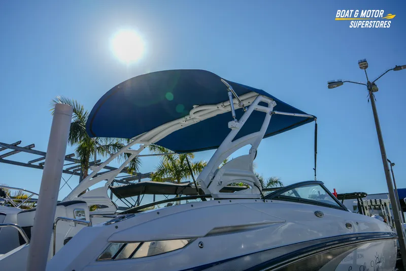 Slide: The Image of 2020 Monterey M-65 boat with blue canopy under bright sun at dealership. - 13