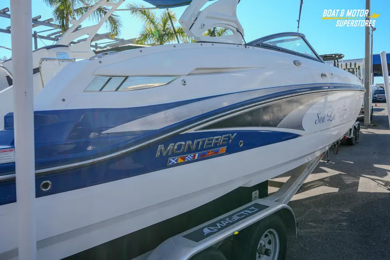 Slide: The Image of 2020 Monterey M-65 boat on trailer at dealership, featuring sleek design and vibrant graphics. - 14